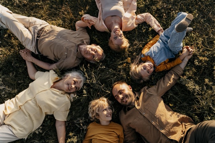 Usmiata rodina ležiaca v&nbsp;tráve